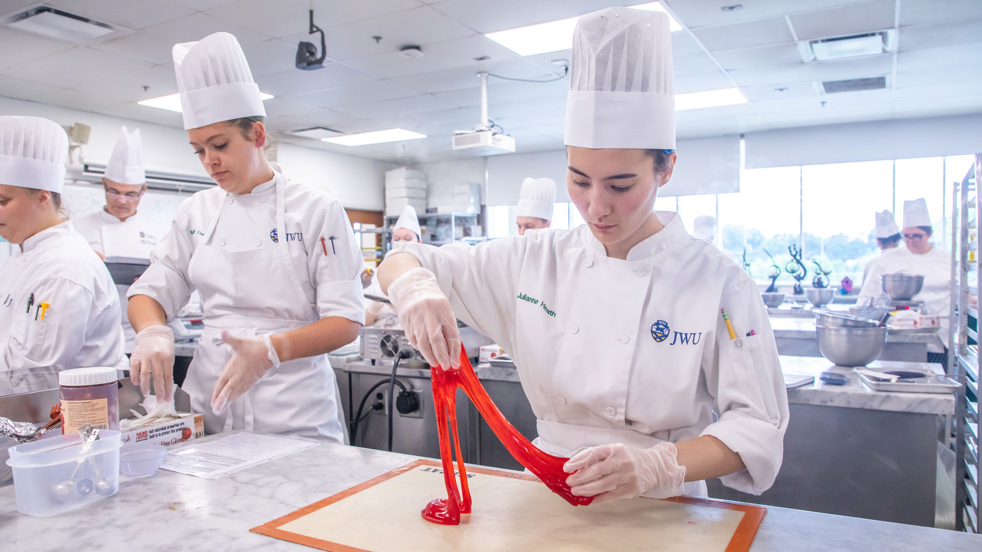 Practicing advanced sugar-pulling techniques in a baking & pastry lab.