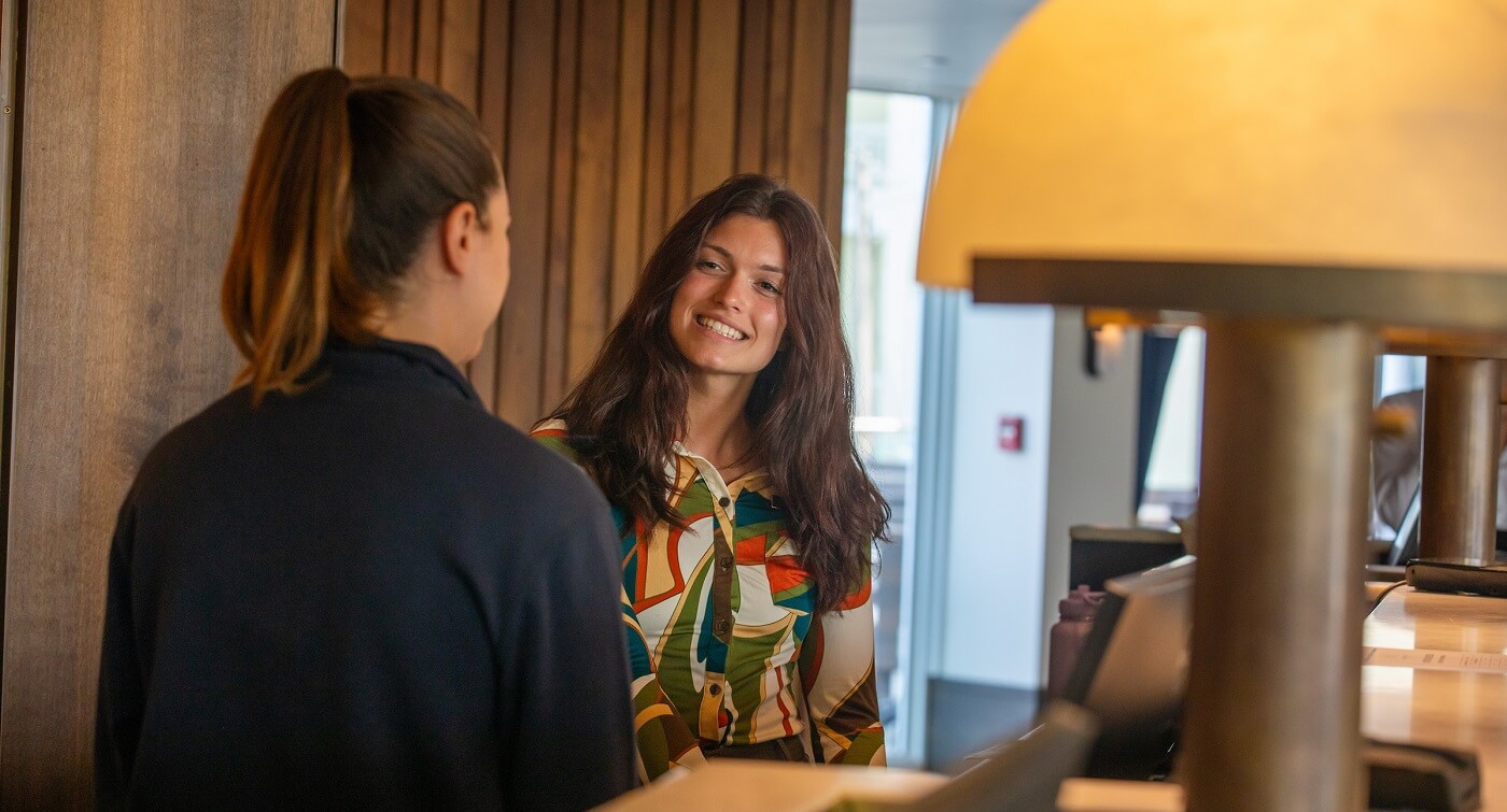 Hospitality student behind hotel front desk at internship