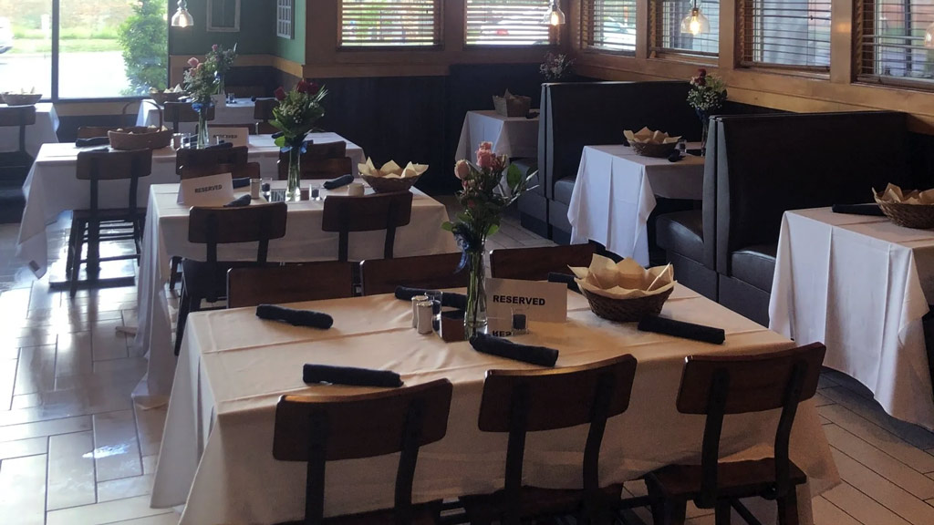 photo of the interior of a restaurant with empty tables set for guests