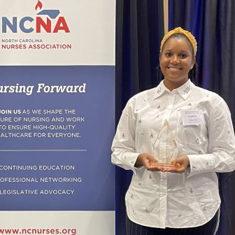 a photo of Caitlin Lofton holding her NCNA award