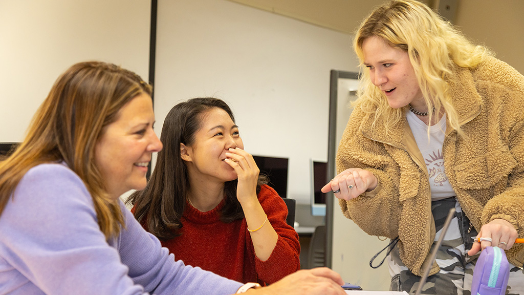 students searching a computer with their professor