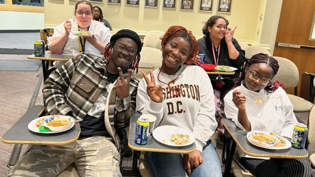 students pose smiling at an Afrocentric Culinary Cuisines club meeting