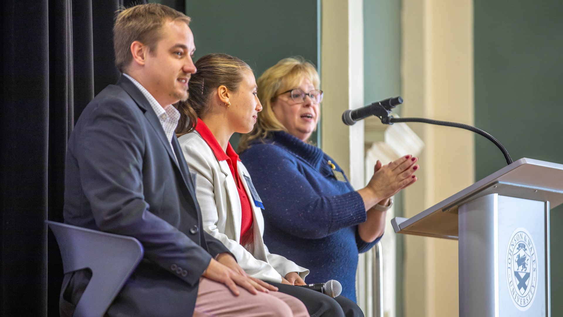 Hospitality alumni and Dean Galipeau on stage at poidum