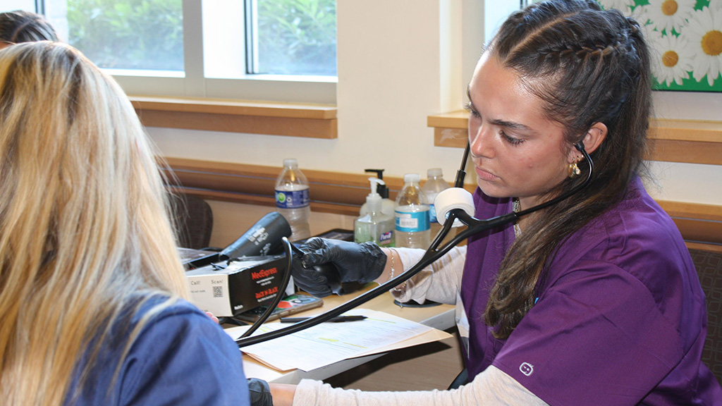 A nursing student taking a patient's blood pressure