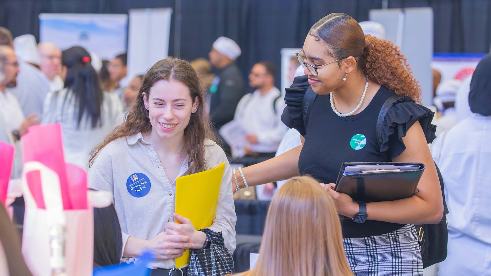 Two people exchanging a handshake at a Johnson & Wales Career Fair.